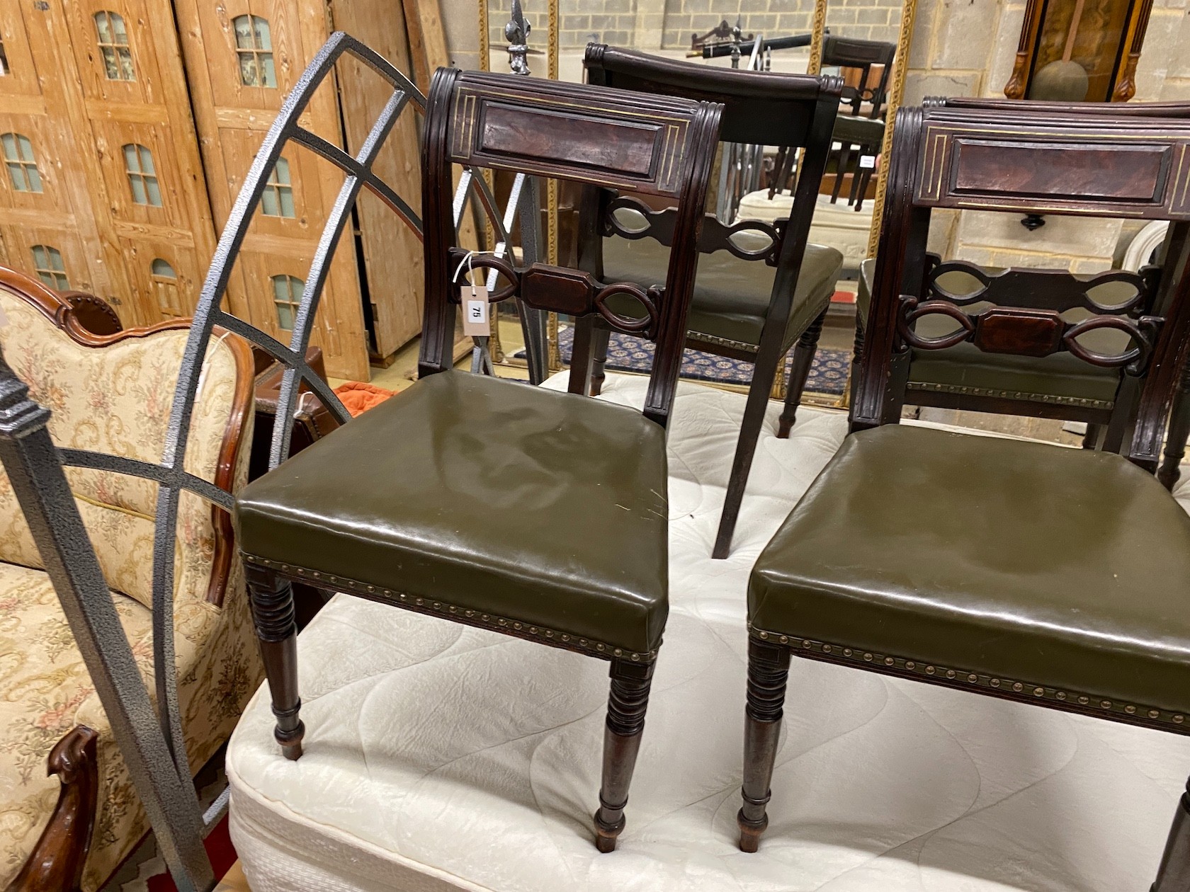 A set of six Regency brass inlaid mahogany dining chairs with green leather seats